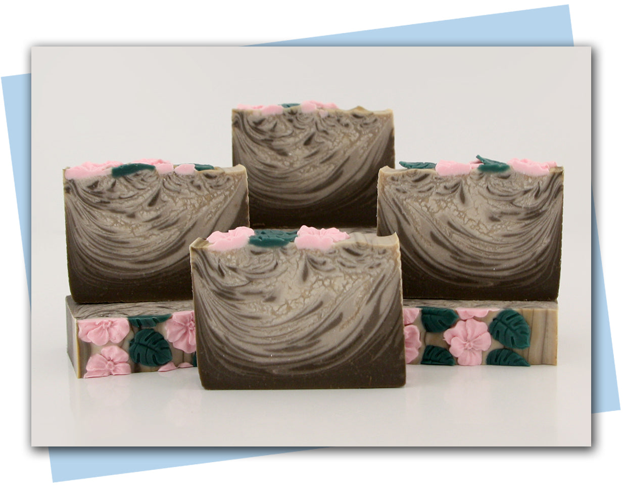 brown and white swirled soap with pink flowers on top bars of soap