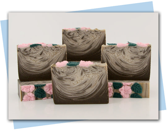 brown and white swirled soap with pink flowers on top bars of soap