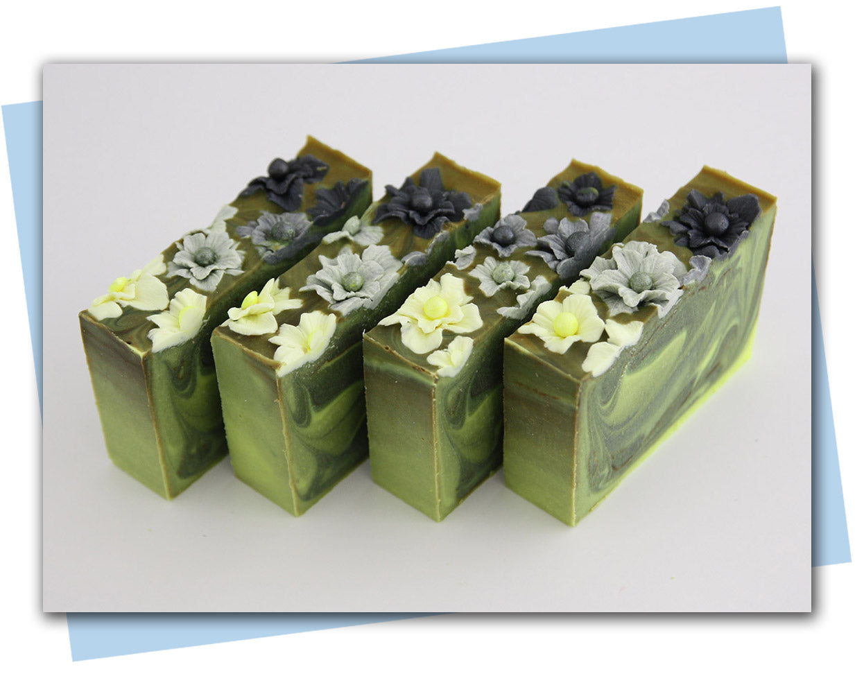 Green and black swirled soaps with yellow to black ombre flowers on top