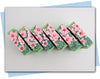 Bars of soap with pink flowers on soap and a green cactus embeds in a green swirl