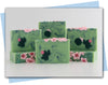 Bars of soap with pink flowers on soap and a green cactus embeds in a green swirl