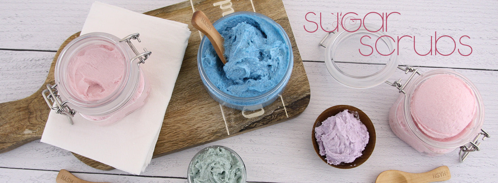 Jars of sugar scrub on a decorative background