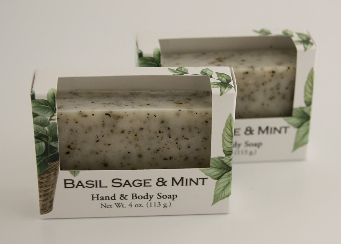 Bars of soap in custom packaging with peppermint leaves in a white bar