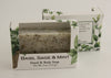 Bars of soap in custom packaging with peppermint leaves in a white bar