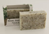 Bars of soap in custom packaging with peppermint leaves in a white bar