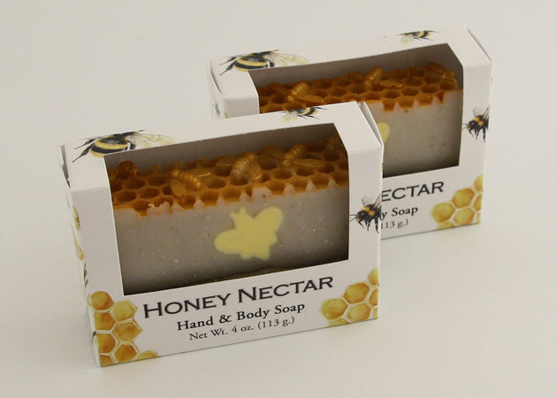 Bars of soap in custom packaging with bee soap design and honey comb pattern on the top of the bar