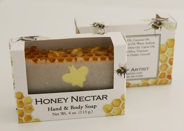 Bars of soap in custom packaging with bee soap design and honey comb pattern on the top of the bar