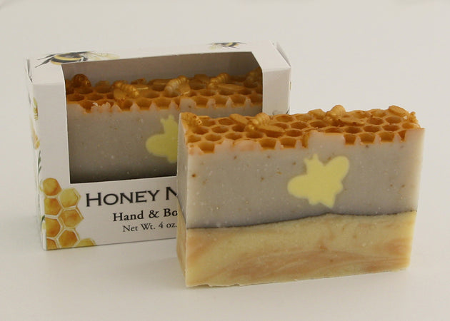 Bars of soap in custom packaging with bee soap design and honey comb pattern on the top of the bar