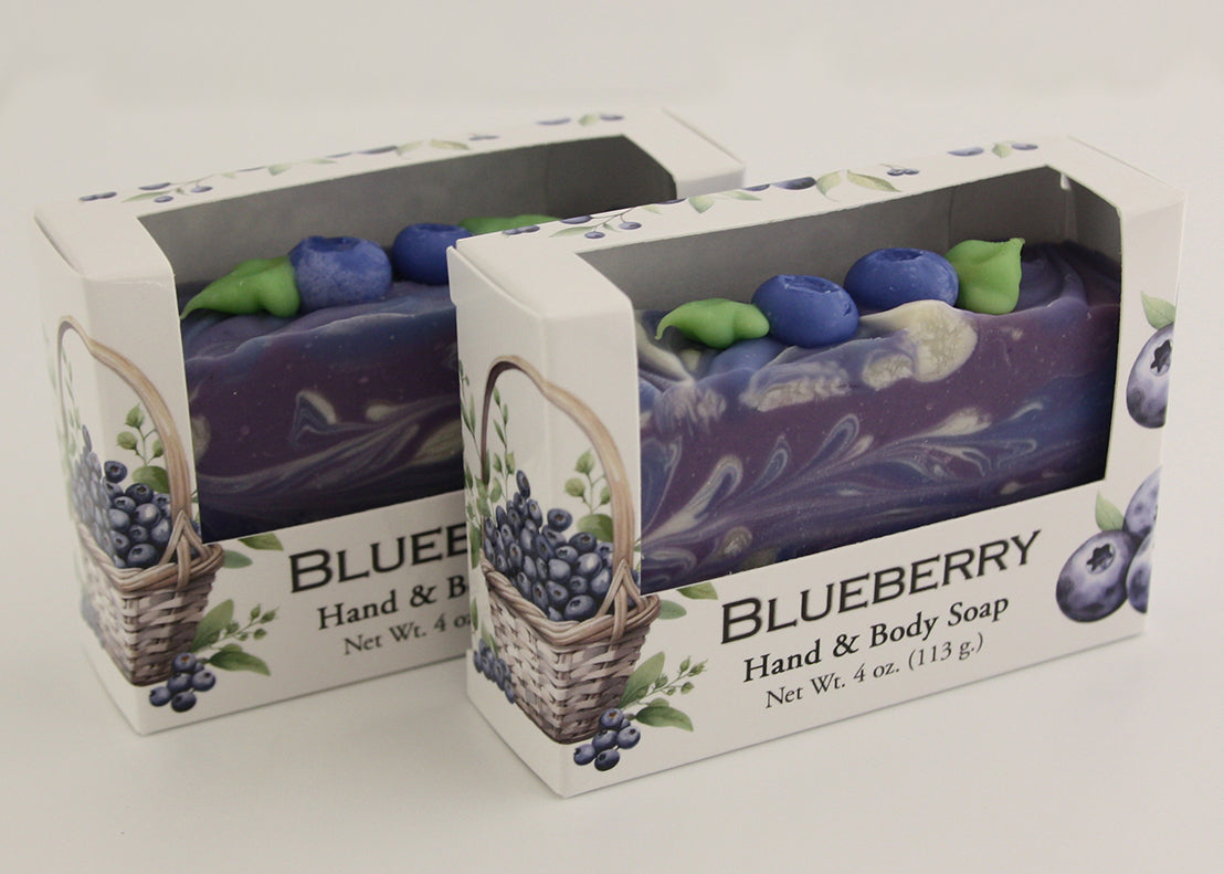 Bars of soap in custom packaging with blueberry and swirl design