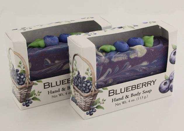 Bars of soap in custom packaging with blueberry and swirl design