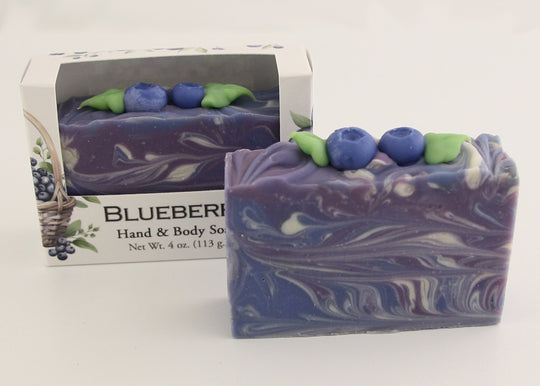 Bars of soap in custom packaging with blueberry and swirl design