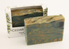 Bars of soap in custom packaging with swirl design green gold and black