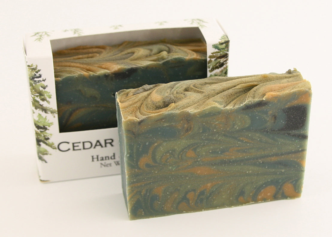 Bars of soap in custom packaging with swirl design green gold and black