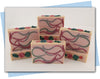pink and green swirls in a bar of soap with clover and vine top embellishements