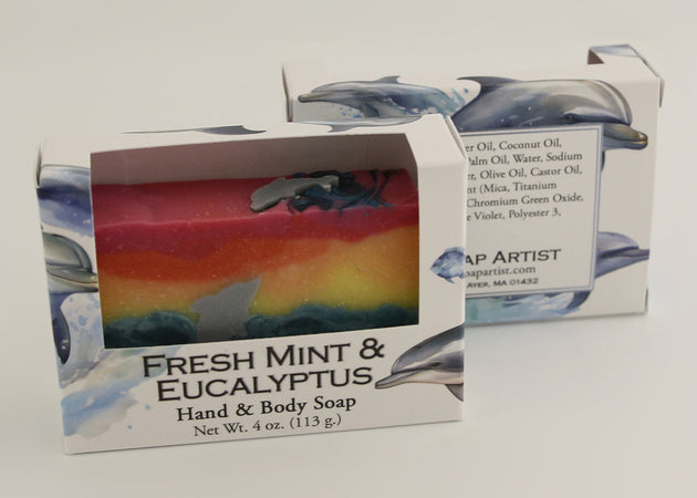 Bars of soap in custom packaging with with a dolphin jumping out of the water in  a sunset design