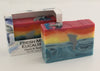 Bars of soap in custom packaging with with a dolphin jumping out of the water in  a sunset design