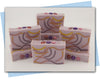 bars of soap with a yellow pink and purple swirl and flower embellishments on top