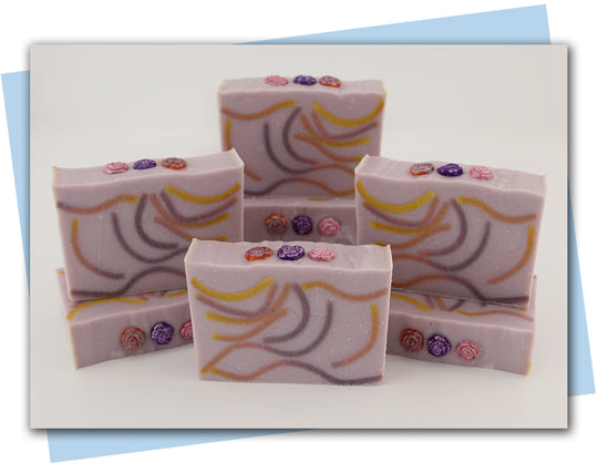 bars of soap with a yellow pink and purple swirl and flower embellishments on top