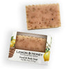 A bar of lemon and honey exfoliating hand and body soap shown both unwrapped above its illustrated retail box on a white background.