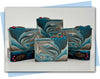 Bars of soap with a green white and brown ombre swirl with pinecones decorating the top of the bar