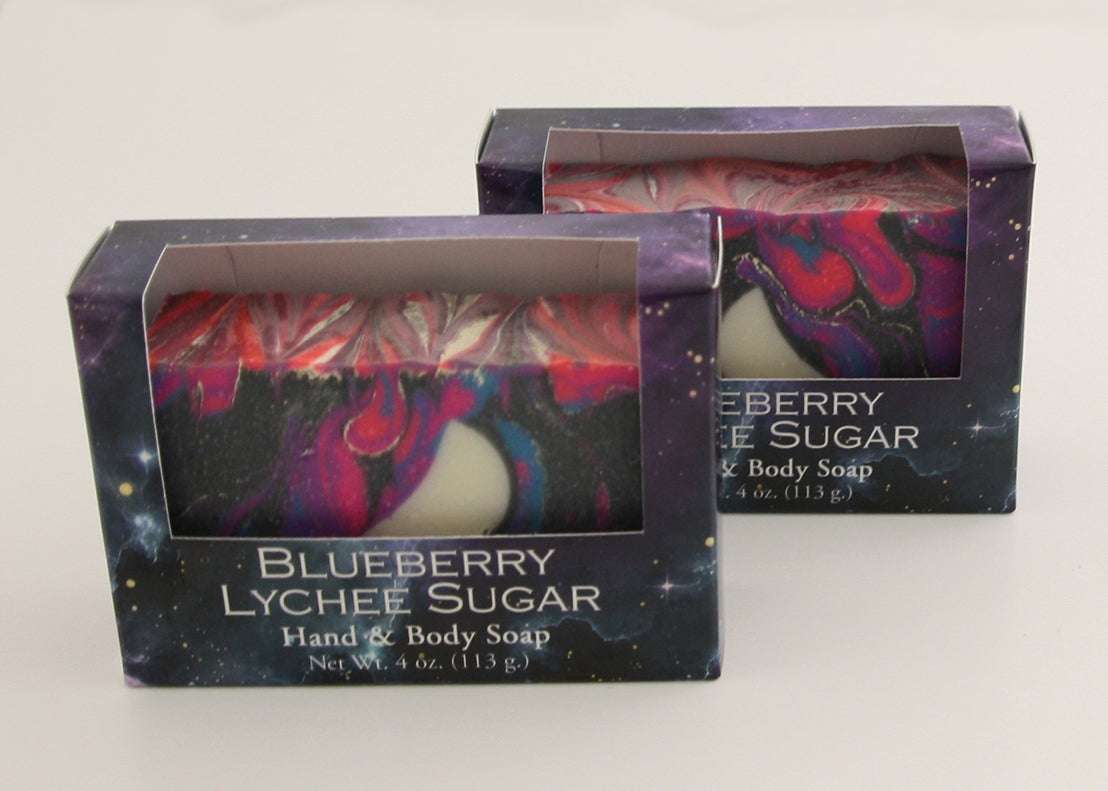 Bars of soap in custom packaging with moon embed and swirl design in black and neon colors