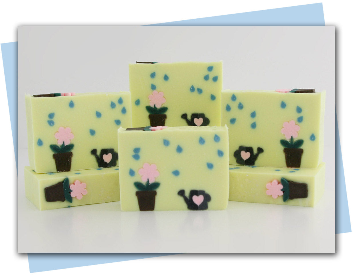 yellow bars of soap with a plant in a flower pot and a watercan with rain drops