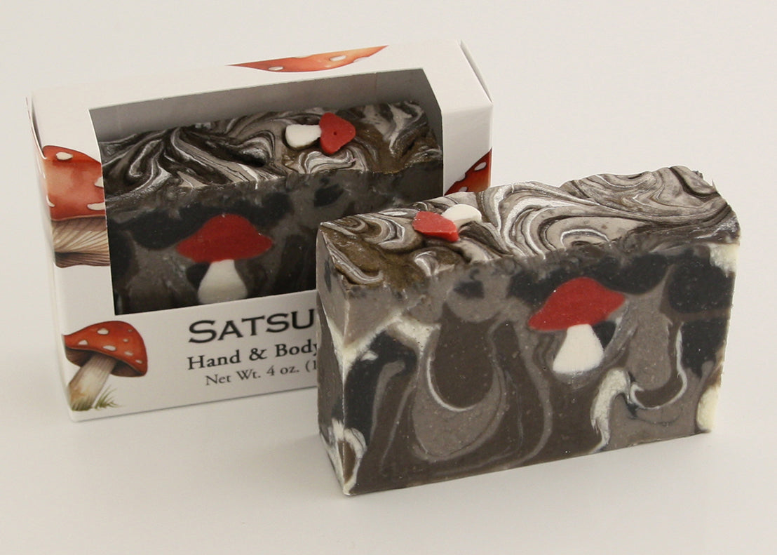 Bars of soap in custom packaging with with mushroom soap embed and swirl design