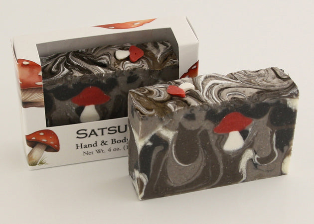 Bars of soap in custom packaging with with mushroom soap embed and swirl design