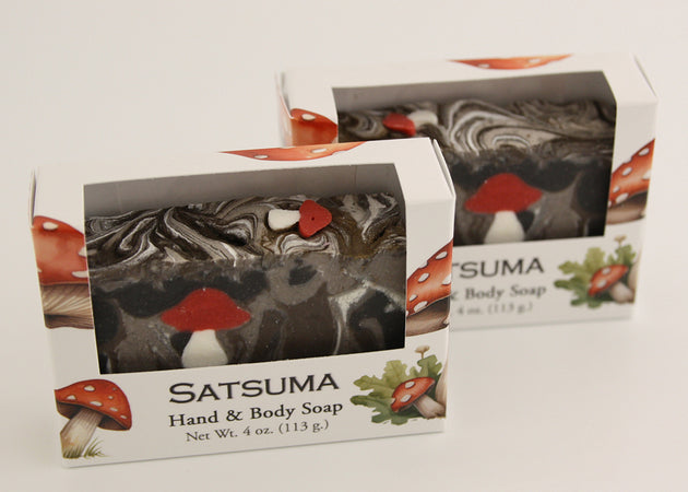 Bars of soap in custom packaging with with mushroom soap embed and swirl design