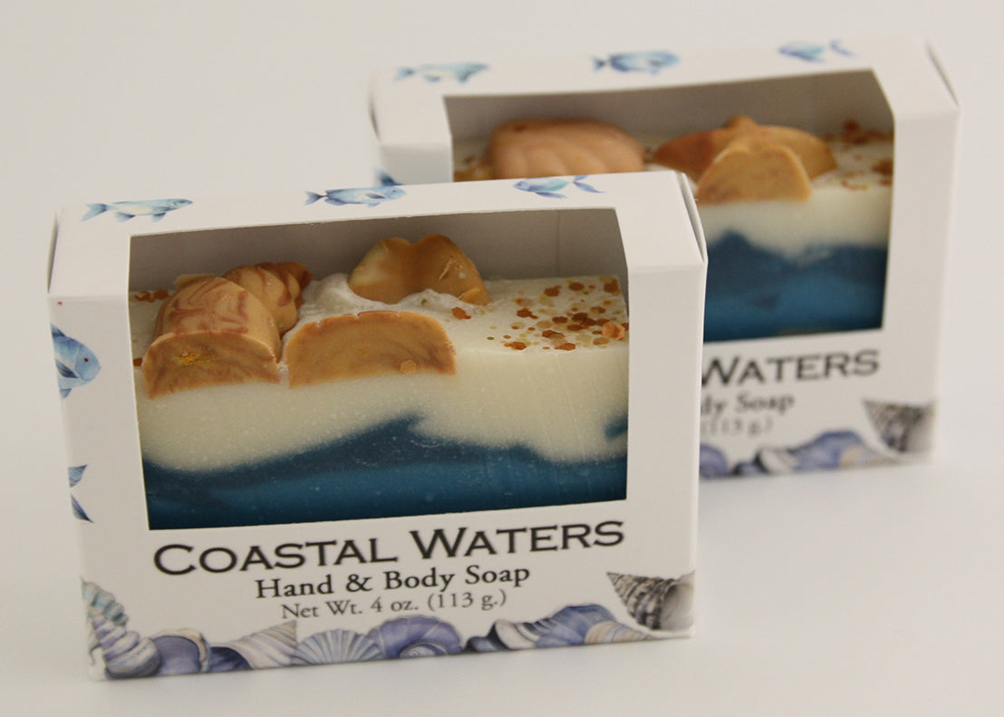 Bars of soap in custom packaging with seashells on top and ocean blue design for the bar