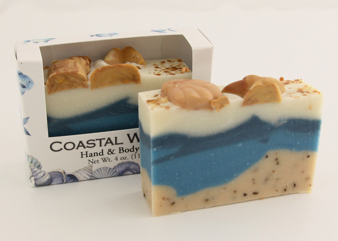 Bars of soap in custom packaging with seashells on top and ocean blue design for the bar