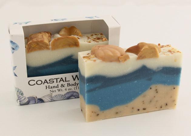 Bars of soap in custom packaging with seashells on top and ocean blue design for the bar