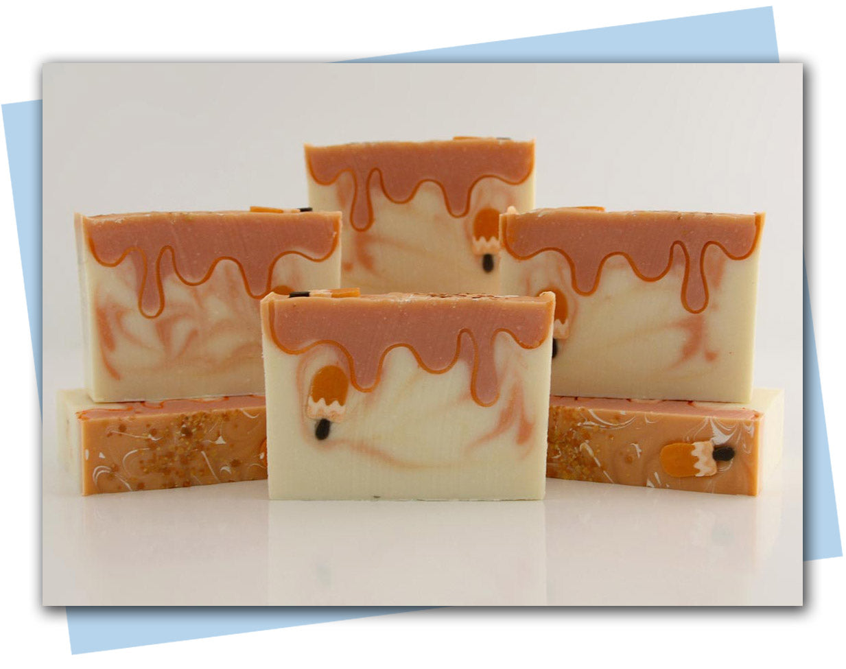 BArs of orange creamsicle soap with a popsicle embeds and design to look like a melting popsicle