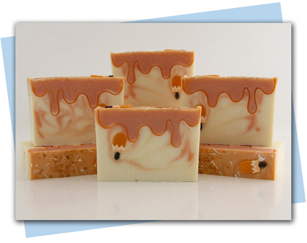 BArs of orange creamsicle soap with a popsicle embeds and design to look like a melting popsicle
