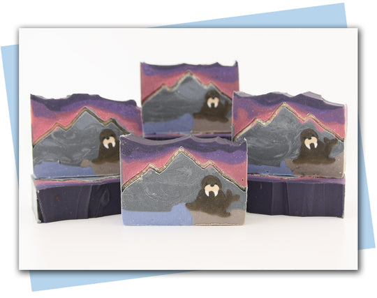 Walrus sitting on a rock looking over the ocean with mountains in the background bars of soap
