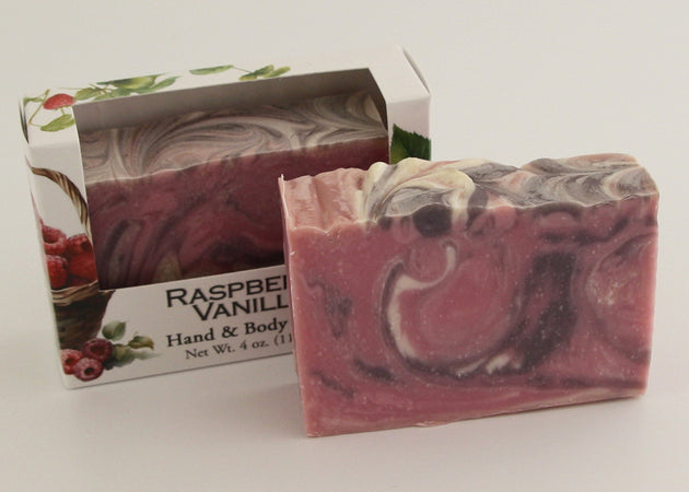 Bars of soap in custom packaging with purple, pink, and white swirl design