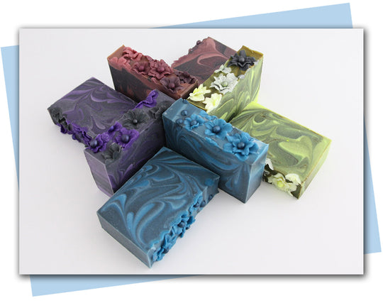 Green and black swirled soaps with yellow to black ombre flowers on top