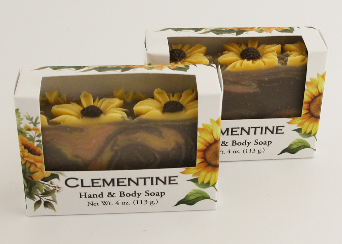 Bars of soap in custom packaging with sunflowers on top and swirl design in brown yellow and orange