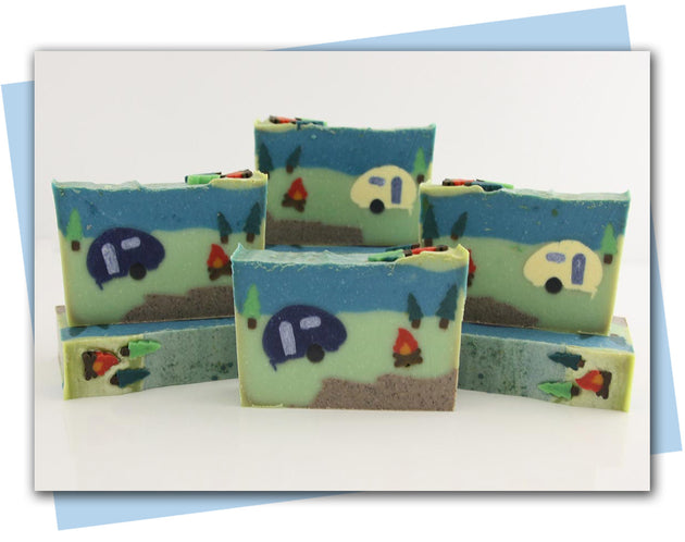 Bars of soap with a camping themed design with a camper, fire, and trees