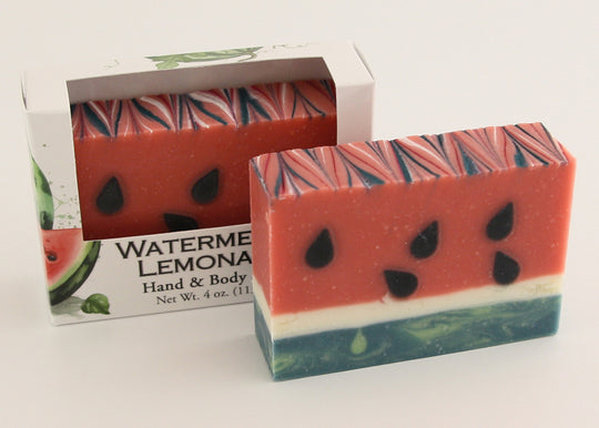 Bars of soap in custom packaging made to look like a watermelon with green bottom layer and black seeds in the pink layer